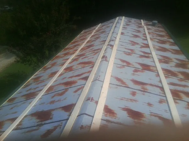 Rusted metal roof panels with new wood purlins before replacement — Storm Damage Roof Repair in Louise by Roofing Brothers